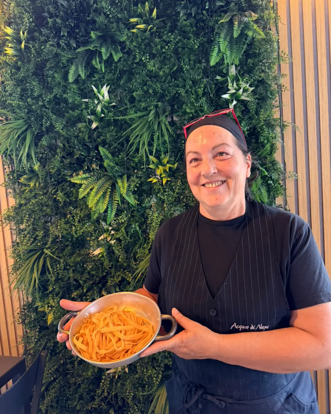 Sabrina sorride in sala e mostra un tegame di fettuccine